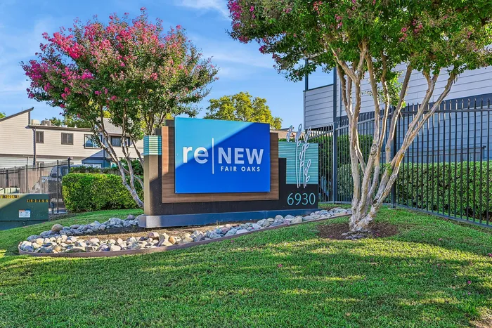 Inviting entrance to ReNew Fair Oaks with vibrant landscaping and modern signage framed by blooming trees.