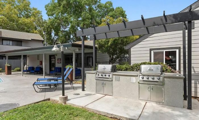 Charming outdoor space featuring modern grills and cozy seating, ideal for entertaining and relaxation.