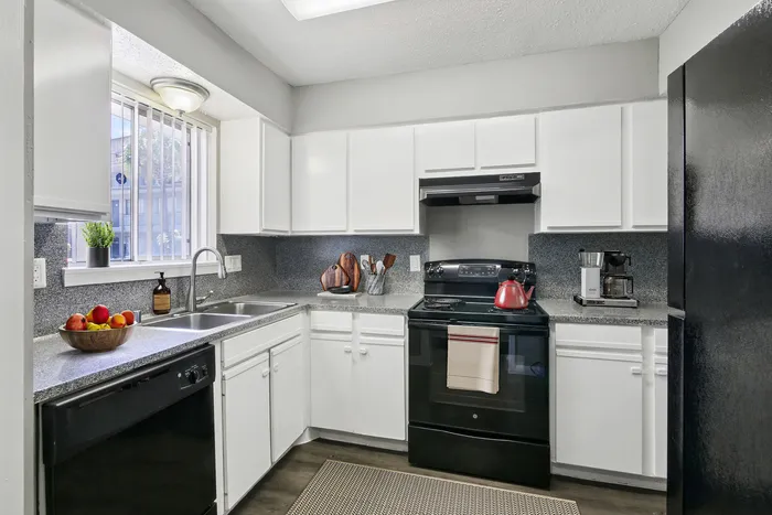 Bright and modern kitchen with sleek white cabinets, granite countertops, and stainless steel appliances, creating an inviting cooking space.