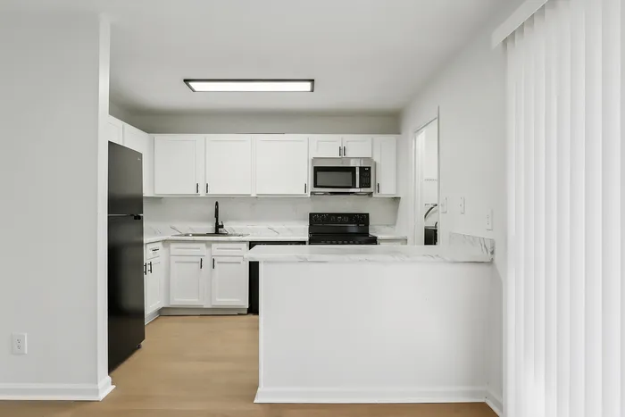 Modern kitchen with sleek white cabinets, elegant marble countertops, and state-of-the-art appliances.