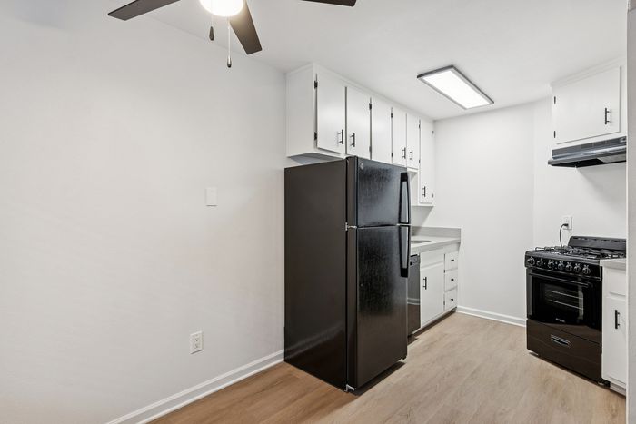 Modern kitchen with sleek black appliances, white cabinetry, and elegant flooring offers a stylish and functional space.