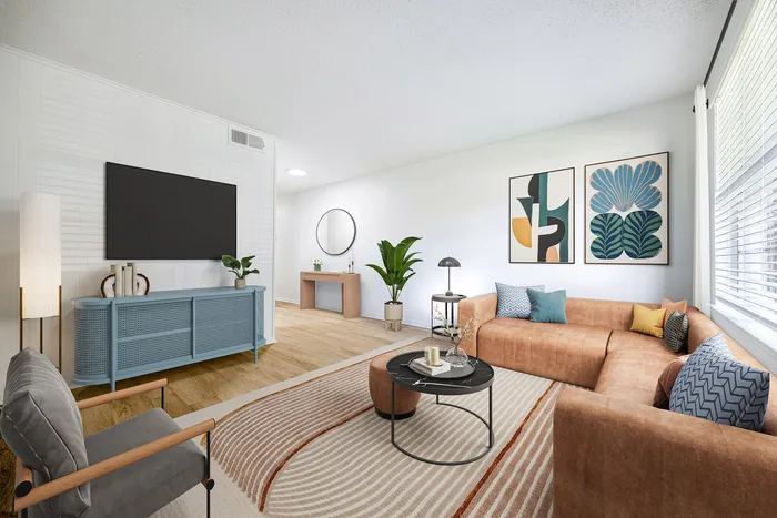 Chic living room with a cozy L-shaped sofa, modern art decor, bright natural lighting, and stylish wooden flooring.