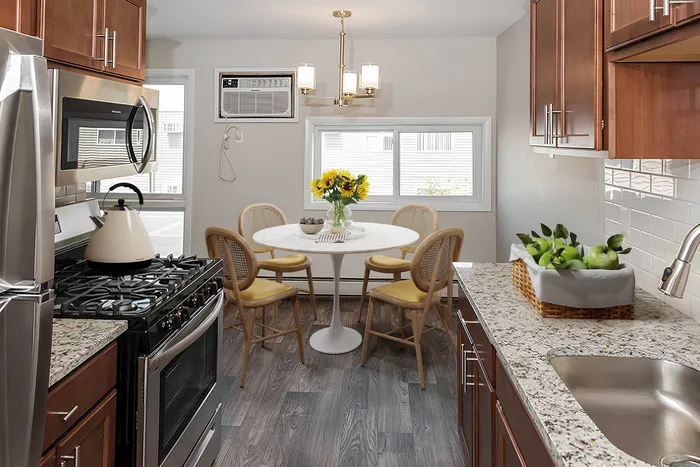 Charming kitchen with modern stainless steel appliances, elegant granite countertops, and a cozy dining area with sunflowers on the table.