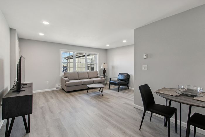 Bright and modern living space with sleek furniture, abundant natural light, and elegant flooring in a stylish open-concept layout.