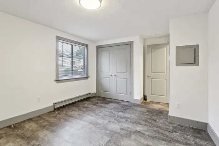 Bright and inviting room with modern flooring and ample natural light, perfect for a cozy apartment space.