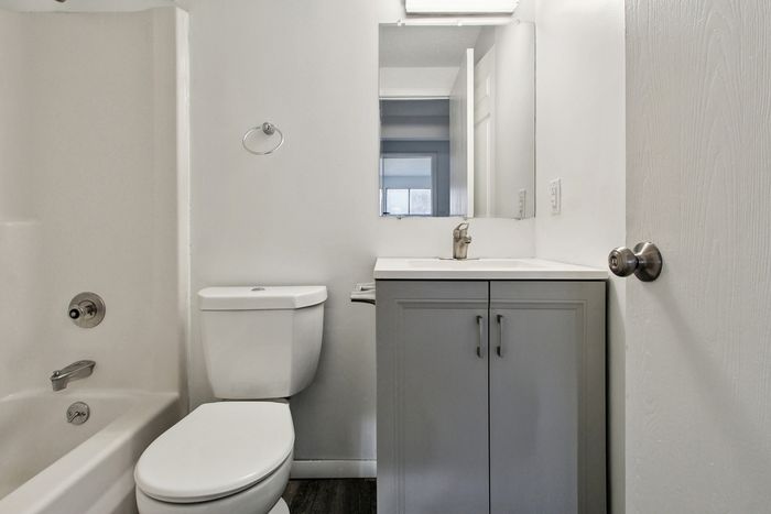 Sleek and modern bathroom featuring elegant fixtures, a pristine bathtub, and a stylish vanity for a clean and inviting atmosphere.