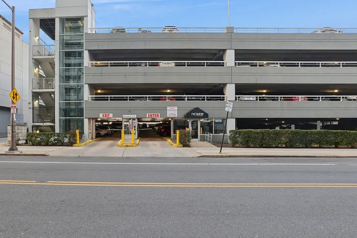 Modern multi-level parking garage with convenient entrance and exit, offering ample parking space in a prime location.
