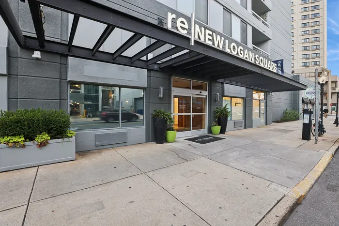 Modern apartment entrance with sleek design and welcoming greenery at reNEW Logan Square.