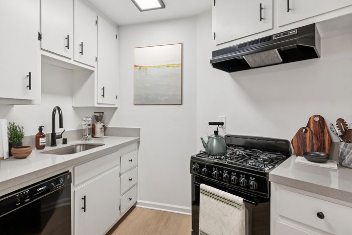 Chic modern kitchen with sleek white cabinetry, stainless steel appliances, and elegant countertops.