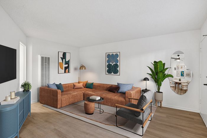 Chic and cozy living room featuring a stylish brown sectional sofa, modern artwork, and vibrant indoor plant, exuding contemporary elegance.