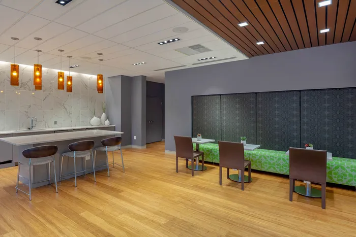 Modern kitchen and dining area featuring sleek countertops, stylish pendant lighting, and contemporary furniture.