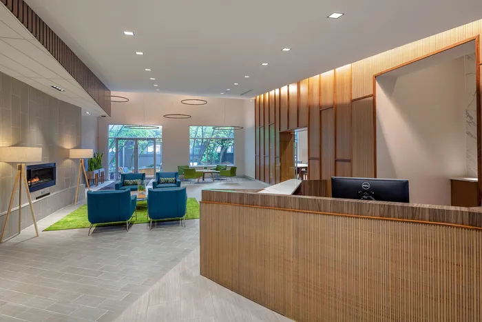 Elegant lobby area featuring modern seating, warm lighting, and a cozy fireplace, perfect for welcoming guests.