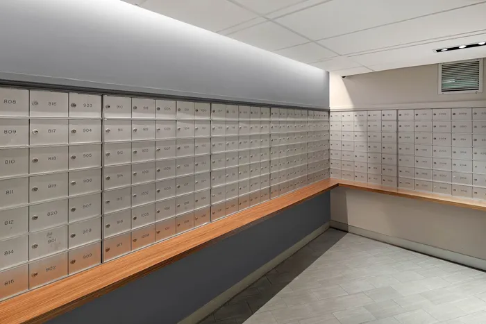 Contemporary mailroom featuring sleek metal mailboxes with wood accents, creating a secure and stylish community space.