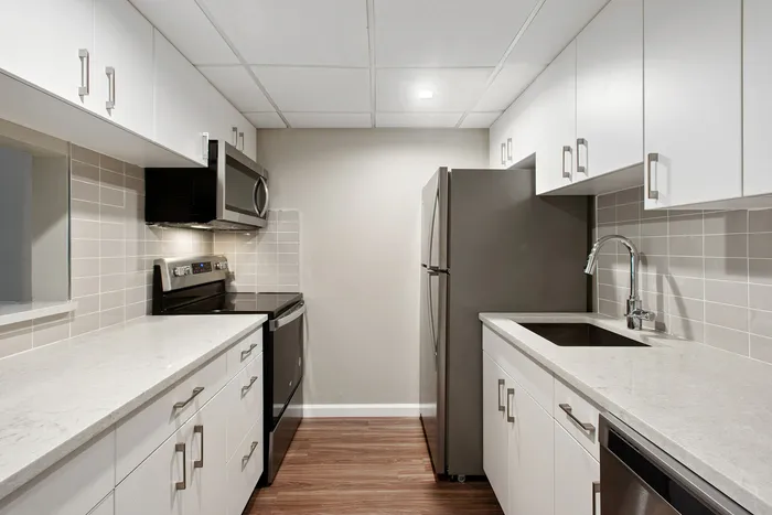 Modern, sleek kitchen with white cabinetry, stainless steel appliances, and elegant countertops.