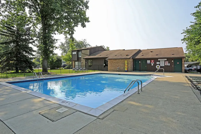 Inviting outdoor swimming pool surrounded by lush greenery and modern amenities, perfect for relaxation and leisure.