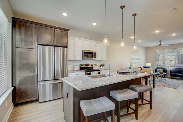 Chic open-concept kitchen and living area featuring modern appliances, sleek countertops, and cozy seating.
