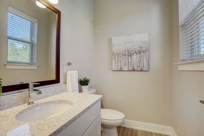 Elegant bathroom showcasing a sleek granite countertop, stylish chrome fixtures, and tasteful wall art, complemented by natural light.