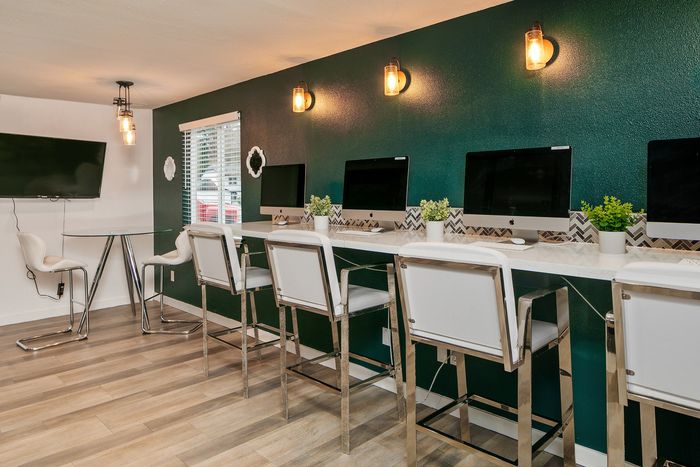 Modern co-working space with sleek computer stations, bright lighting, and chic seating, perfect for productivity and collaboration.
