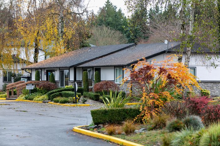 Charming single-story apartment with lush landscaping, vibrant autumn foliage, and direct access to the leasing center.