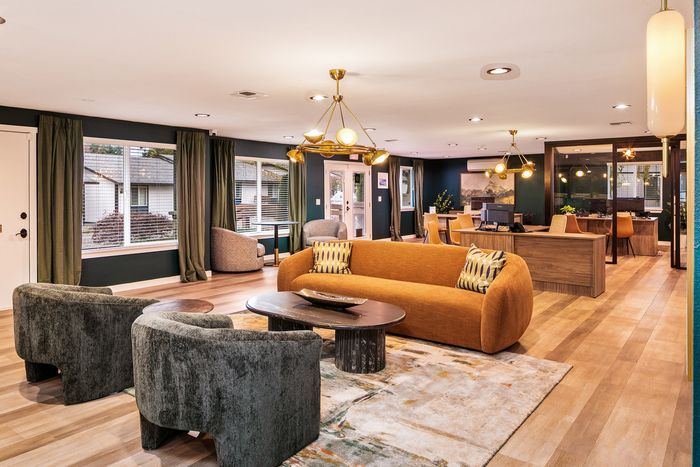 Elegant, spacious living area with modern decor, warm lighting, and large windows overlooking a garden view.