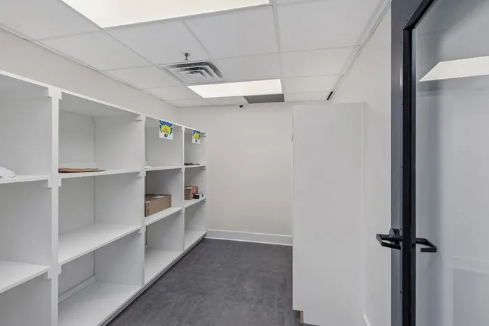 Sleek storage room with modern white shelving and ample space for organization.