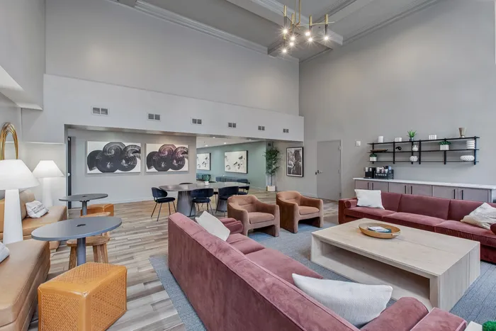 Luxurious and spacious living area featuring plush pink and tan seating, modern decor, and elegant lighting, perfect for relaxing and entertaining.
