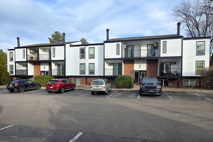 Modern apartment building with captivating architecture, featuring spacious balconies and ample parking in a serene neighborhood setting.