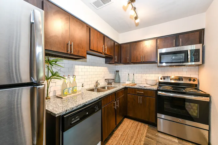 Modern kitchen with sleek stainless steel appliances, dark wood cabinets, and elegant white subway tile backsplash.
