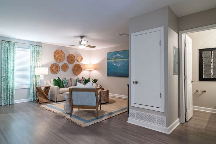 Bright and inviting living room featuring chic decor, a cozy seating area with vibrant cushions, and elegant wall art.