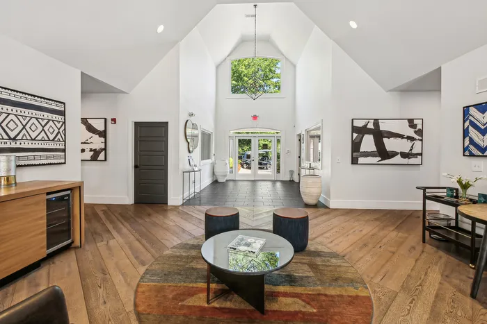 Bright and welcoming apartment lobby with high ceilings, modern decor, and stylish artwork.