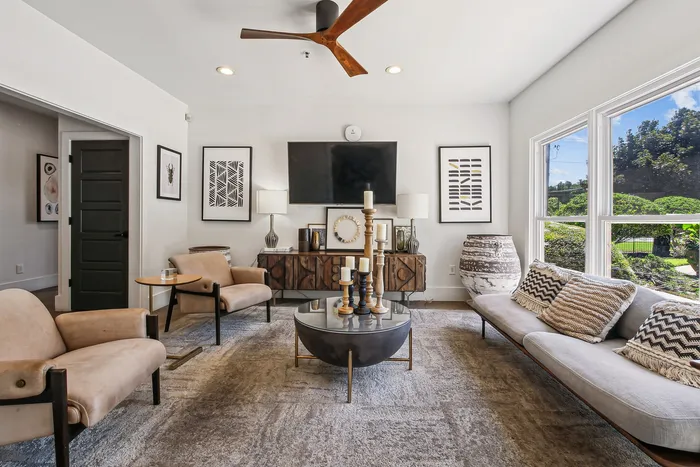 Elegant living room featuring chic modern decor, plush seating, and large windows with abundant natural light.