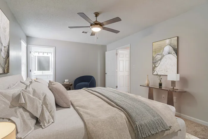Inviting bedroom with cozy gray tones, featuring a plush bed, elegant decor, and an ensuite bathroom for ultimate comfort.