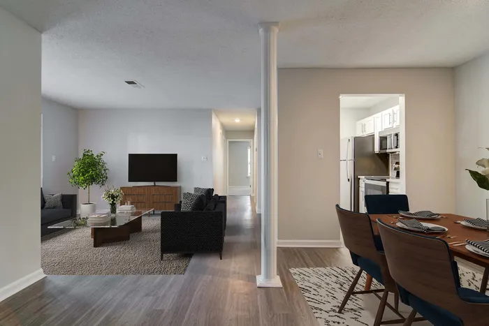 Modern open-plan apartment interior showcasing a stylish dining area, cozy living room with elegant decor, and a sleek kitchen.