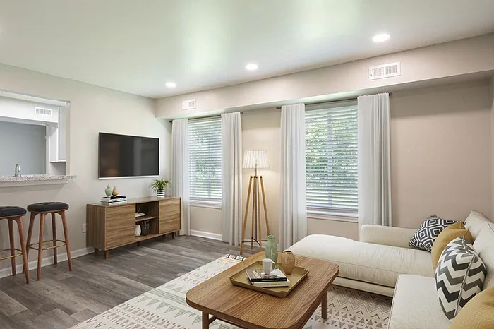 Inviting living room with modern decor, featuring a comfy sectional sofa, stylish wooden coffee table, and sleek entertainment center beneath a mounted TV.