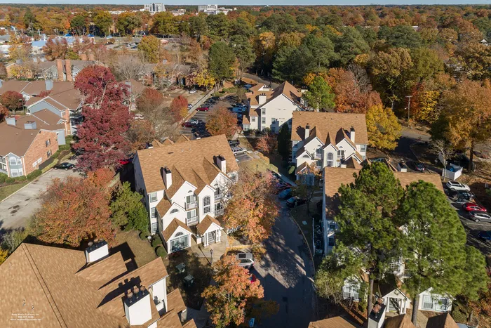 Charming aerial view of a picturesque residential area with cozy homes surrounded by vibrant autumn foliage.