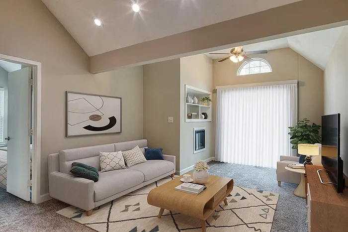 Inviting living room with vaulted ceilings, elegant decor, and abundant natural light, featuring a cozy gray sofa and modern coffee table.