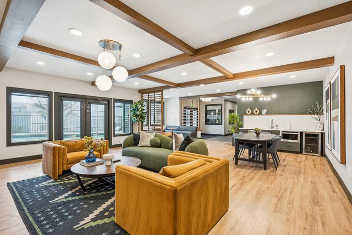 Chic, open-concept living space featuring modern lighting and elegant furniture, with a cozy seating area and stylish dining table.