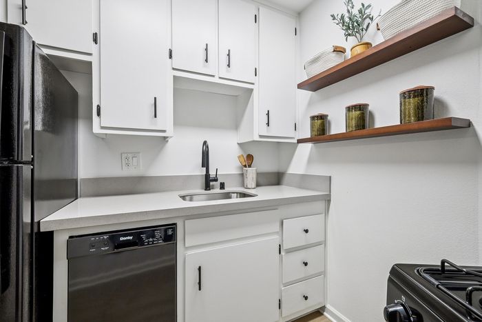 Modern kitchen with sleek cabinetry, stainless steel appliances, and elegant open shelves for a chic, organized look.