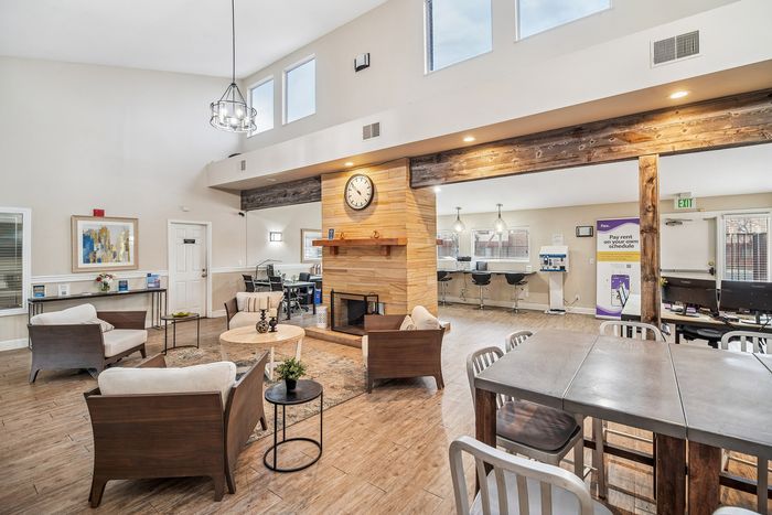 Inviting community lounge with modern design, featuring cozy seating, a stylish fireplace, and a convenient business center.