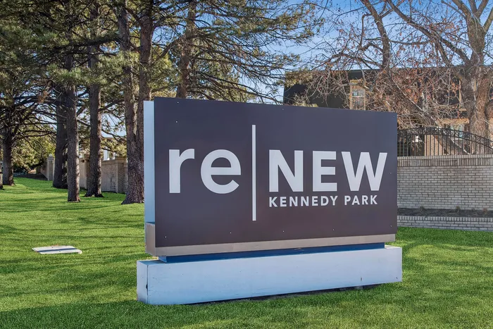 Inviting sign for reNEW Kennedy Park nestled in a serene and lush green landscape.