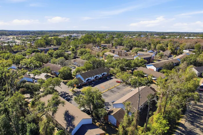 Townhomes at TSC Charming aerial view of a serene residential community nestled among lush greenery, showcasing spacious townhomes with ample parking.