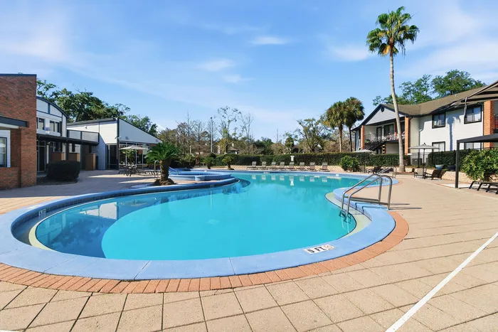 Townhomes at TSC Luxurious apartment complex featuring a pristine swimming pool surrounded by modern architecture and lush greenery.