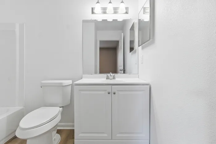 Townhomes at TSC Elegant bathroom with modern vanity, stylish lighting, and pristine white finishes creating a bright and welcoming space.