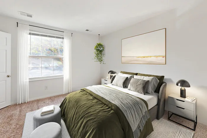 Bright and inviting bedroom with large window, modern decor, and lush green accents.