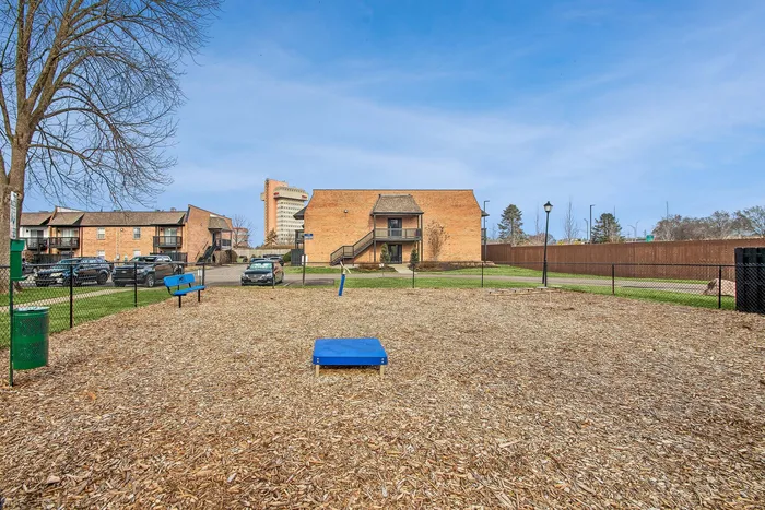 Charming apartment complex surrounded by open green spaces and a vibrant community area, perfect for outdoor activities and relaxation.