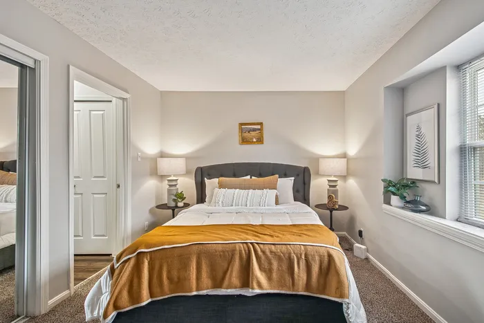 Cozy and inviting bedroom with a plush bed, accent pillows, and elegant nightstands, enhanced by soft lighting and tasteful decor.