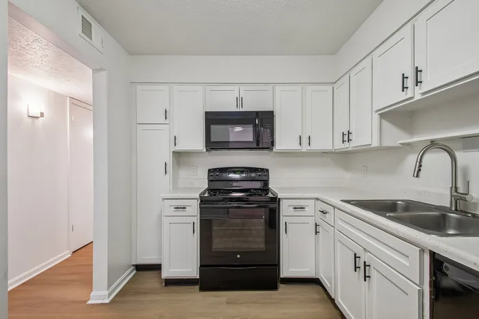 Chic modern kitchen featuring sleek white cabinetry, elegant countertops, and high-end stainless steel appliances.