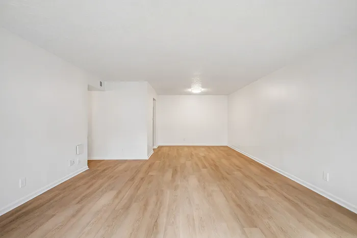 Sophisticated living space with elegant hardwood flooring and a minimalist design, perfect for customizing your dream home.