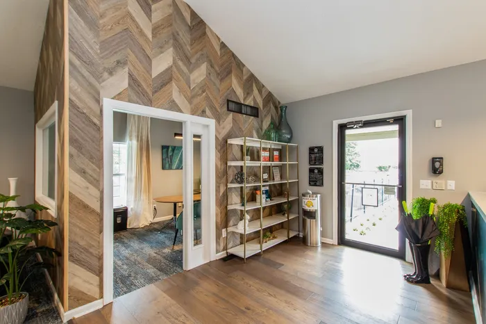 Chic apartment entryway with stylish wood design, elegant shelving, and natural lighting.