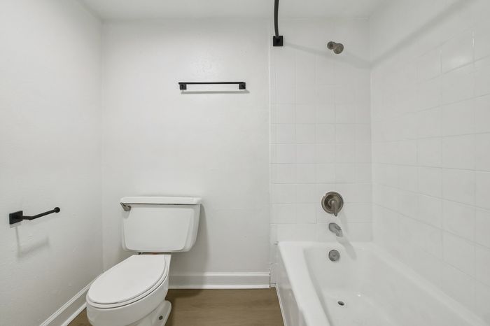 Modern bathroom with sleek white fixtures, bright tiles, and elegant contrasting accents, creating a refreshing and inviting space.